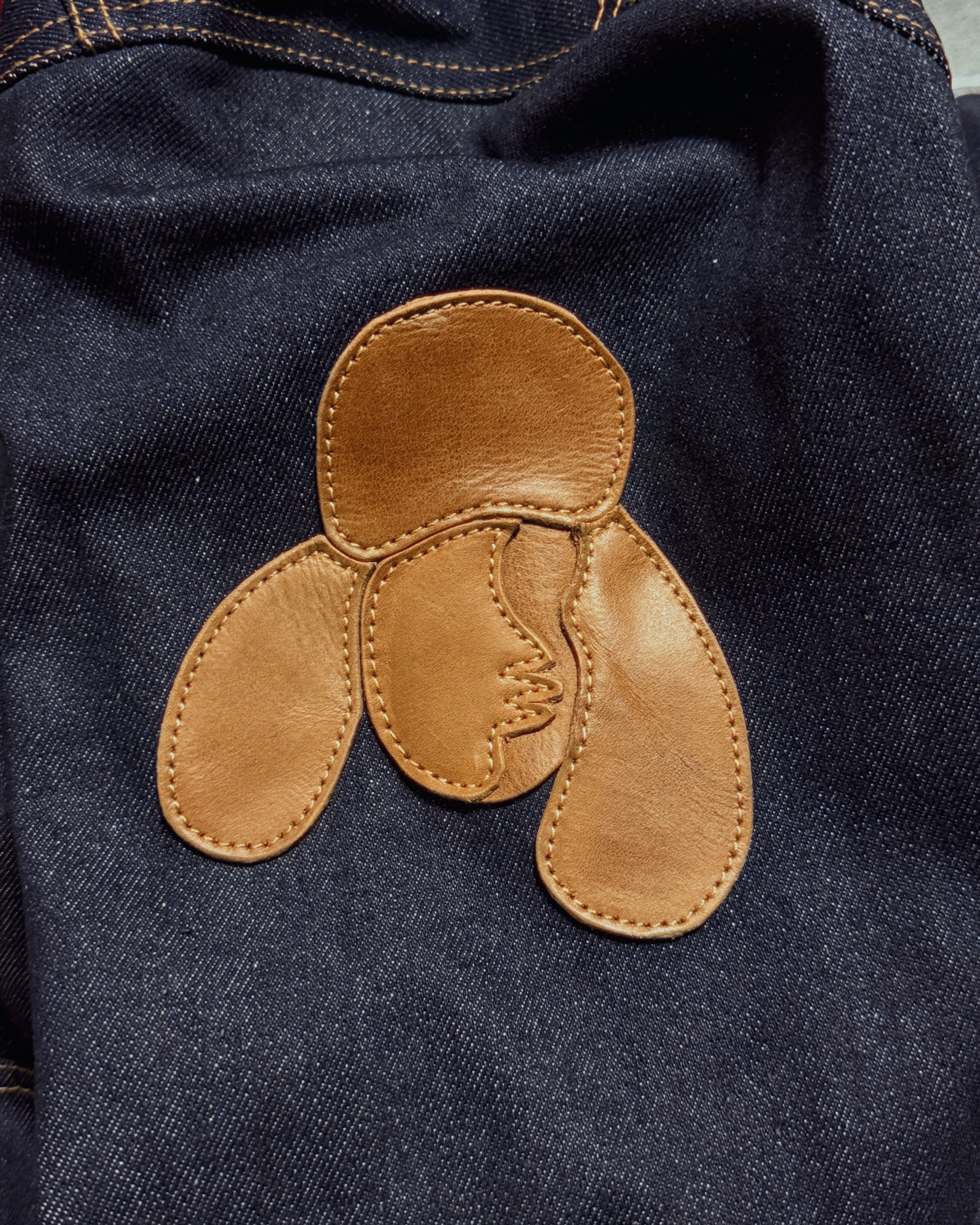 Goat skin leather flower patch on raw denim